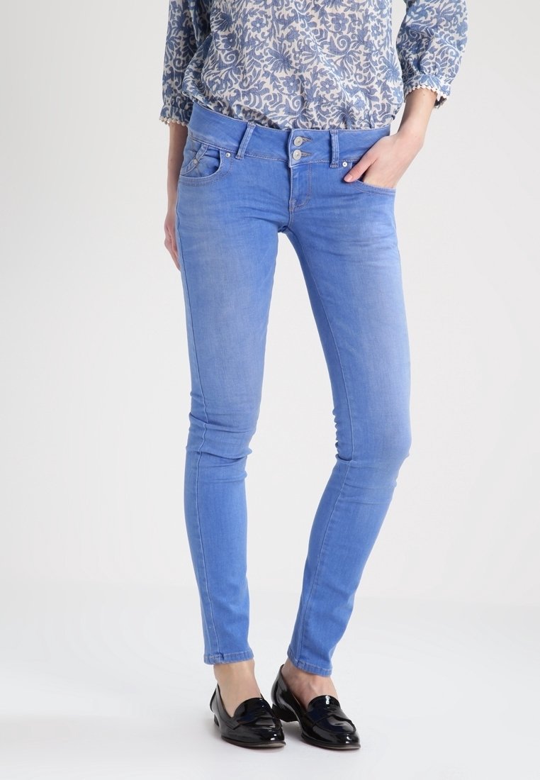 Jean slim bleu clair en denim avec une texture lisse. Dispose de poches avant, fermeture par bouton, et un design classique à cinq poches.