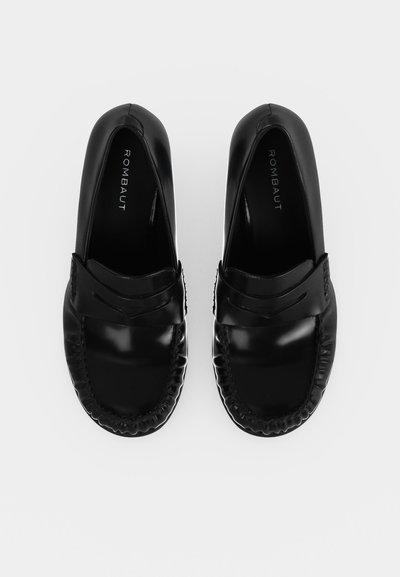 Paire de mocassins en cuir noir brillant avec bouts arrondis et brides décoratives, vue de dessus sur fond blanc.