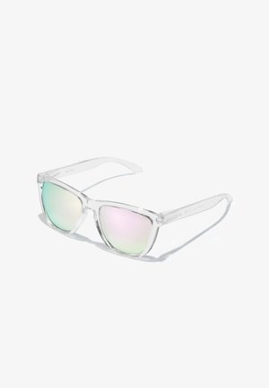 Lunettes de soleil transparentes avec montures angulaires, verres teintés affichant un dégradé du vert au rose, avec des bords lisses et des branches claires.