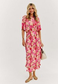Květinové midi šaty s živými vzory v růžové, červené a zelené barvě, krátkými rukávy, elastickým pasem a volným siluetou.