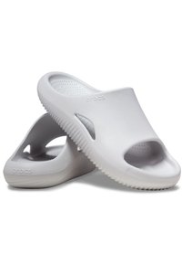 Scarpe bianche slip-on realizzate in materiale leggero, con design open-toe, soletta testurizzata e motivo ondulato sulla suola.
