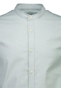 Camisa azul clara con cuello, hecha de tela con una textura suave, que presenta una tapeta con botones blancos y detalles sutiles de costura.