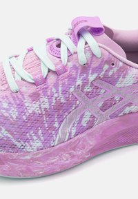 Lila Sport-Schuh mit einem Farbverlauf-Obermaterial, strukturiertem Mesh-Material, integriertem Schnürsystem und einer halbtransluzenten pinken Sohle.