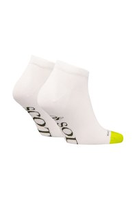 Weiße Knöchelsocken mit einem grünen Logo-Muster und einer neon-gelben Spitze. Hergestellt aus einem glatten, dehnbaren Material, das für Komfort und Passform sorgt.