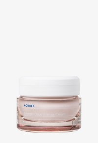 Crème Intense Korres Brighter Days dans un pot en verre transparent avec une teinte rose et un couvercle blanc ; étiquetée avec des détails du produit en texte bleu.