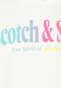 Valkoinen kangas, jossa on rohkeaa tekstiäGradientti-väreissä, lukien "Scotch & Soda" ja "Vapaa Amsterdam-henkisyys" alla sinisellä ja keltaisella.
