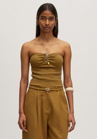 Braunes, geripptes, schulterfreies Oberteil mit einem gerafften Zentrum und metallic Detail. Kombiniert mit hoch taillierten, weiten Hose im gleichen Stil.