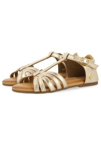 Sandal in metallo dorato con punta aperta, design a T, multiple cinghie decorative, fibbia laterale regolabile e suola piatta marrone.
