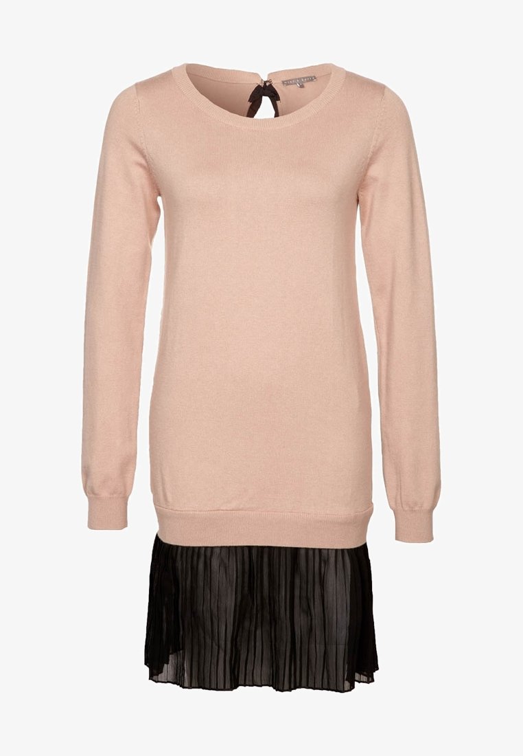 Robe pull manches longues rose clair avec encolure ronde et jupe noire plissée transparente attachée à l'ourlet.