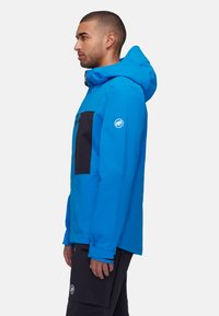 Blue and black waterproof jacket with a hood, featuring a zippered chest pocket and logo on the sleeve, tailored fit with a smooth texture.