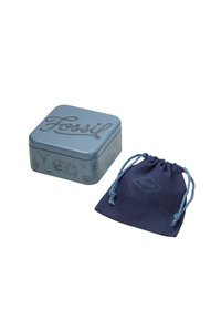 Square, light blue metal tin with embossed "Fossil" logo and decorative illustrations. Accompanied by a dark blue fabric pouch with matching branding.