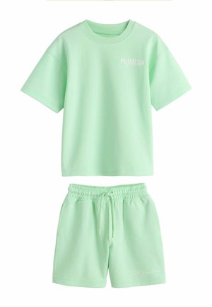 Mentolovo zelené tričko s krátkym rukávom s nápisom "Palm Beach Florida" a zodpovedajúce šortky so sťahovacou šnúrkou a vreckami.