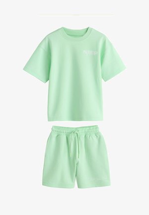 Svijetlozelena kratkih rukava majica s natpisom "Palm Beach Florida" i odgovarajuće kratke hlače s džepovima i vezicom.