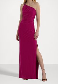 Fuchsia enaxelklänning med samlad tyg vid axeln och en sidöppning. Tillverkad av ett mjukt, elastiskt material. Betonas med detaljer i metall.