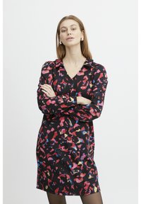 Schwarzes Kleid mit V-Ausschnitt, das ein farbenfrohes abstraktes Muster in Pink, Blau und Gelb zeigt. Lange Ärmel mit Knopfdetails.