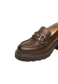 Mocassino in pelle marrone con suola a battistrada spessa e dettaglio in metallo dorato sulla parte superiore, design della punta arrotondata cucita.