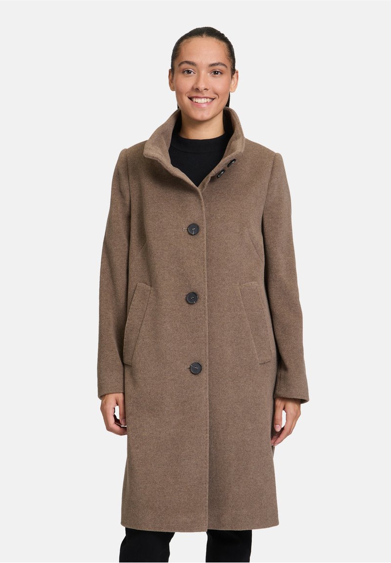 Cappotto in lana marrone con colletto alto, dotato di chiusura a un bottone e due tasche frontali; texture morbida e design su misura.