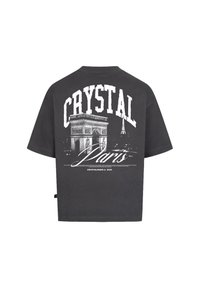 Šedé bavlněné tričko s uvolněným střihem. Na zádech se nachází velký bílý grafický potisk Arc de Triomphe a nápis "CRYSTAL Paris".