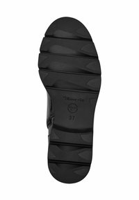 Suola nera di scarpa in gomma texturizzata, con molteplici scanalature di flessione e un tacco arrotondato. Marchiata con "Tamaris" e taglia "37".
