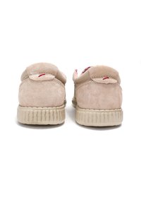 Scarpe in suede beige con tacco arrotondato e collo imbottito. Presentano dettagli in rosso sul tacco e suola in gomma a righe.