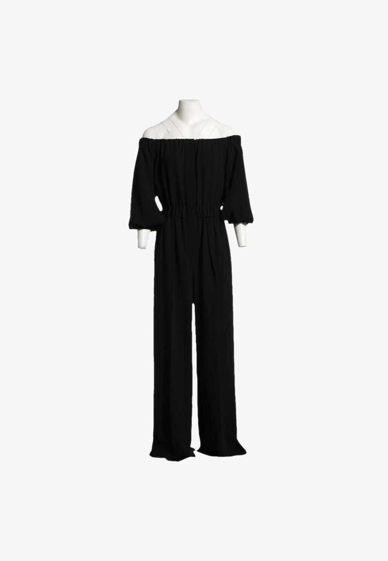 Combinaison noire épaules dénudées avec manches bouffantes aux trois quarts et jambes larges exposée sur un mannequin sans tête.