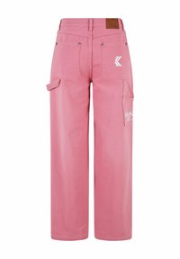 Pantalones cargo rosas de corte holgado, con múltiples bolsillos, costuras visibles y una etiqueta de cuero en la cinturilla.