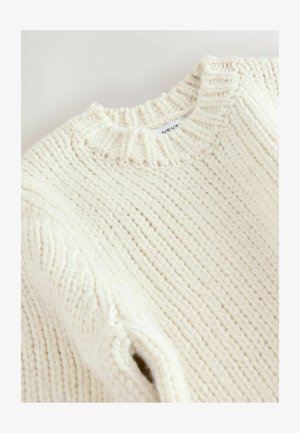 Pulover chunky cu tricotaje cremoase și guler cu nervuri, având un material texturat și umeri căzuți. Eticheta spune "NEXT" pe spate.