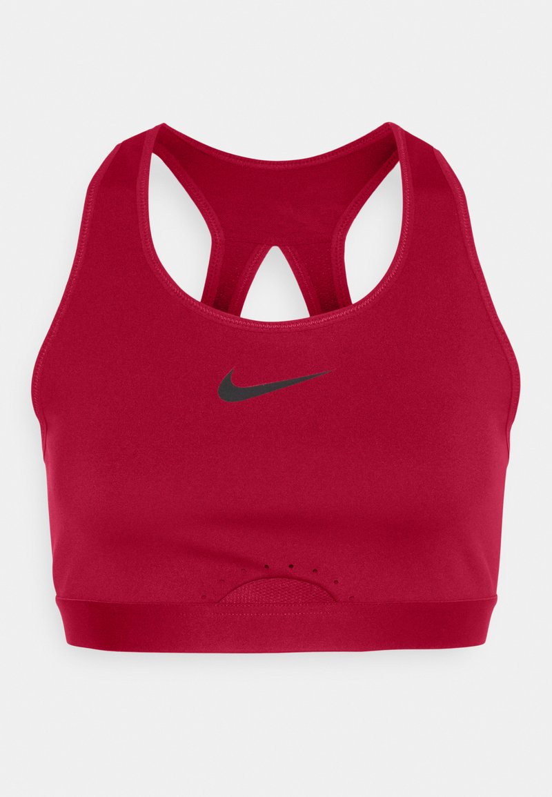 Sostenitore sportivo rosso con design a schiena scoperta, realizzato in tessuto liscio, con un logo Nike nero e dettagli perforati nella parte inferiore.