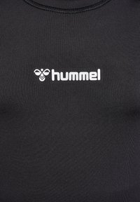 Schwarzes Sportshirt aus glattem, dehnbarem Material. Verfügt über einen runden Halsausschnitt und ein weißes "hummel"-Logo mit einem Emblem.