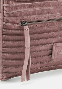 Borsa in pelle rosa con una texture a coste, chiusura con zip dotata di un tirante in tessuto e una patch con logo sul lato.