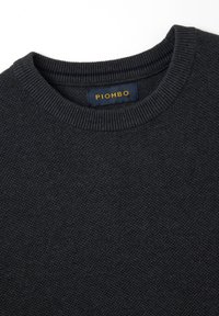 Maglione a maglia grigio scuro con colletto a coste. L'etichetta "PIOMBO" è ricamata in oro su uno sfondo blu navy. Tessuto morbido e texturizzato.