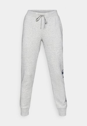 Grå bomullssweatpants med strikk i livet, tettsittende mansjetter og en marineblå logo trykket på venstre side. Glatt, myk tekstur.