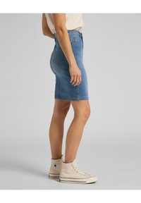 Jupe crayon en denim bleu clair avec une taille haute et une silhouette ajustée. Dispose de deux poches arrière et d'un ourlet au-dessus du genou.