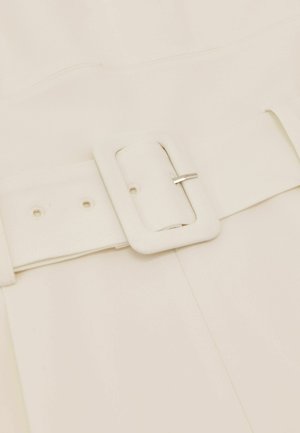 Valge kangast vöö, millel on heledast hallist metallist ristkülikukujuline sile pandlaga. Vööl on reguleeritavad augud ja lame, tekstuuriga rihm.