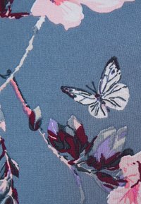 Modrá látka s bílou motýlí a květinovou vzorovou v růžových, fialových a tmavě červených odstínech.