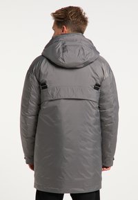 Grå isoleret parka med hætte, lavet af et struktureret stof, justerbare stropper bagpå og designet til at gå til knæene for varme.