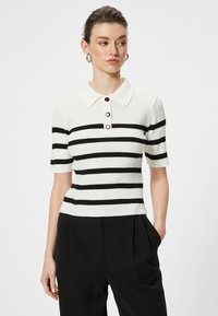Kurzärmliges Polo-Shirt aus Rippstrickstoff mit horizontalen schwarz-weißen Streifen, dreiknopfiger Knopfleiste und weichem Kragen.
