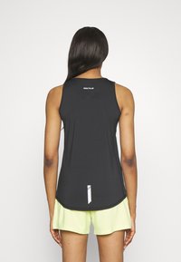 Top sportivo senza maniche di colore nero con orlo arrotondato, dotato di un logo bianco del marchio al collo e un accento bianco sul retro.