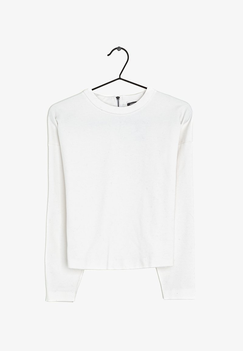 Haut blanc à manches longues en tissu doux, avec un col rond, une coupe décontractée et un détail de fermeture éclair à l'arrière. Sans motifs ni accents.