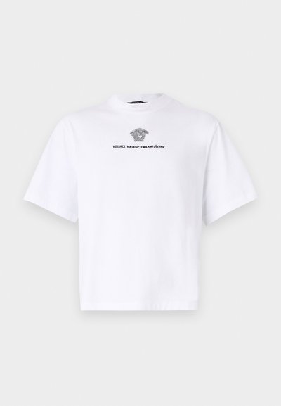 T-shirt branca de manga curta feita de algodão, com decote redondo e uma impressão gráfica preta de uma cabeça e o nome da marca na frente.