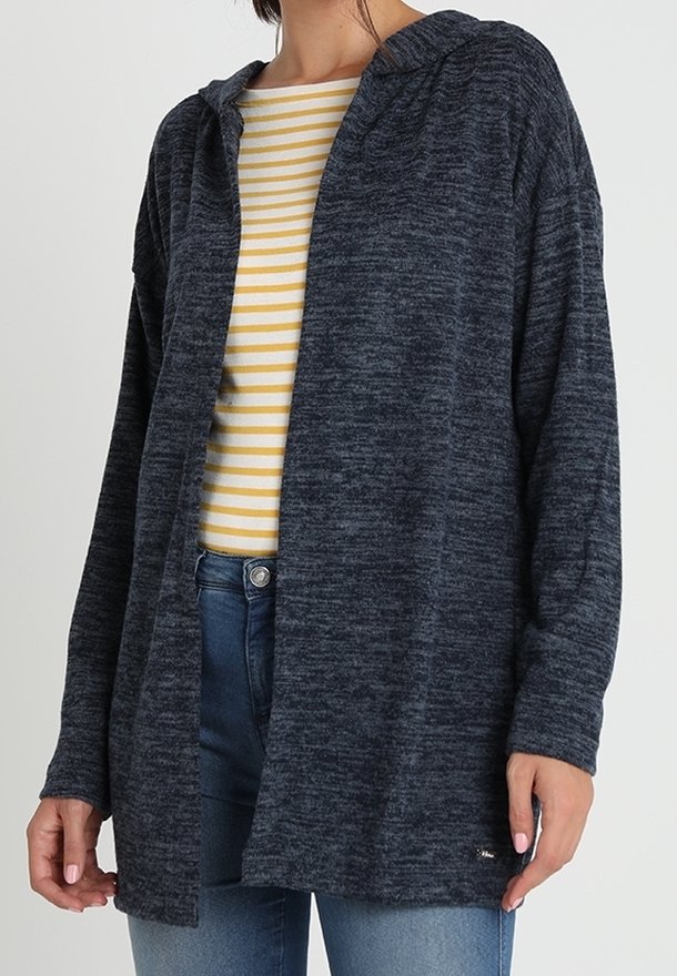 Marinblå, hoodad cardigan i mjukt, strukturerat tyg, med en lös passform och öppen framsida, bärs över en gulrandig skjorta.