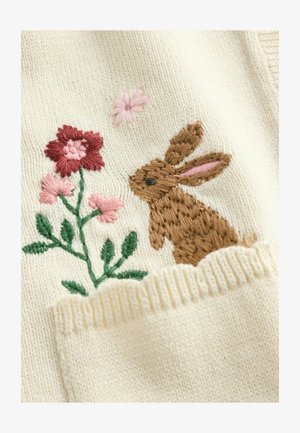 Tikandiga kujundus, millel on pruun jänes roosa ja punase lille kõrval kreemja kangapõhja peal, alumises servas soonikkand.