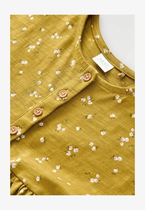 Olivová zelená šaty s malými bielymi a ružovými kvetinovými vzormi, s gombíkovou légou a textúrovanou tkaninou. Značka viditeľná na výstrihu.