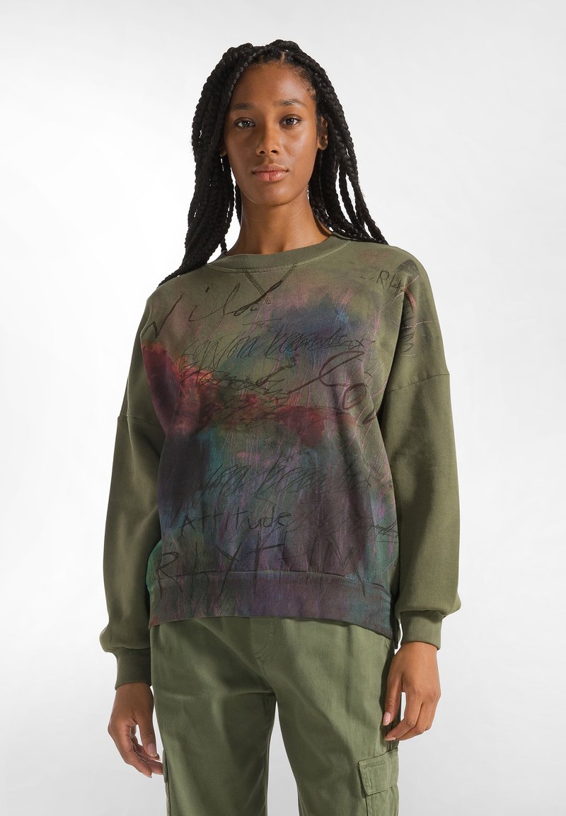 Felpa verde oliva con una grafica astratta multicolore e scritte. Presenta una vestibilità comoda, scollatura rotonda e maniche lunghe.