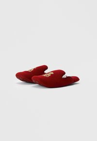 Κόκκινα βελούδινα παν slippers με ανοιχτή μύτη, που διαθέτουν χρυσές διακοσμητικές λεπτομέρειες και υφασμάτινες σόλες για πρόσφυση. Μαλακό υλικό και στρογγυλή μορφή.