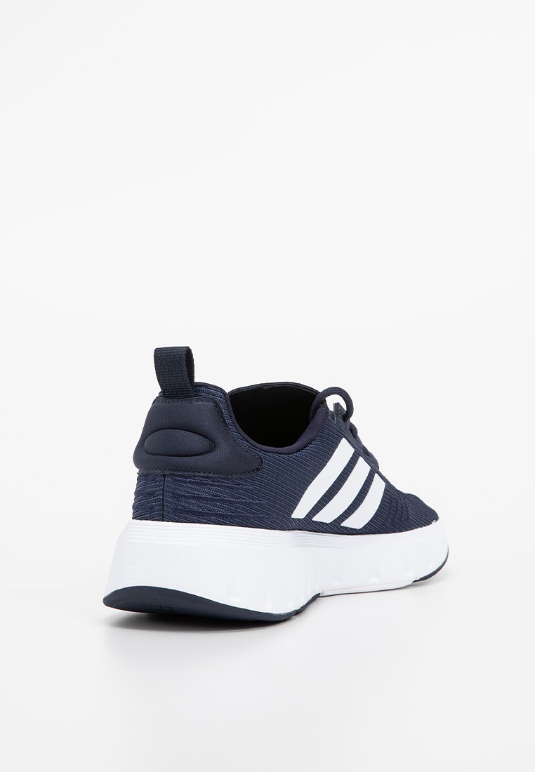 Marineblaue Sportschuhe mit strukturiertem Obermaterial, weißen Streifenakzenten, abgerundetem Absatz und einer gepolsterten weißen Sohle für Komfort.