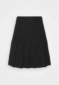 Jupe noire longueur genoux avec taille haute et larges plis le long de l'ourlet, réalisée en tissu texturé.