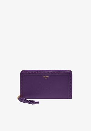 Portefeuille en cuir violet avec fermeture éclair tout autour, tirette à pompon, détails de couture en relief, et logo doré "LANCEL PARIS" au centre avant.