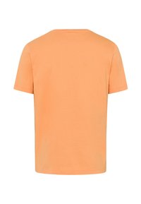 T-shirt a maniche corte in morbido cotone pesca, con un classico scollo rotondo e una vestibilità rilassata. Semplice e di un colore uniforme senza motivi.