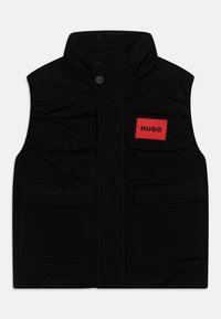 Svart polstret vest med høy krage, frontknapplukking og to store frontlommer. Har et rødt rektangulært merke med "HUGO"-etikett.